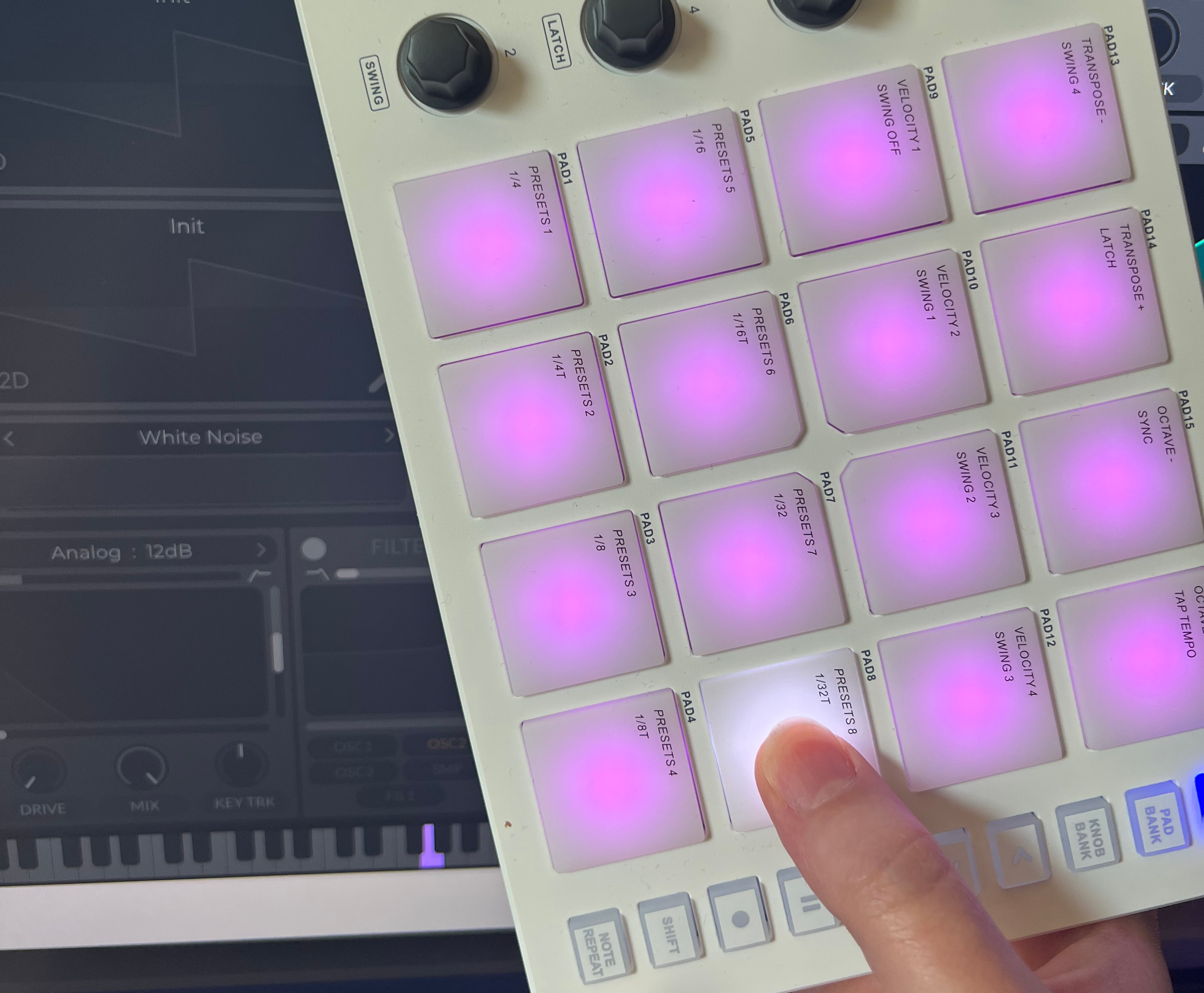 Holding M-VAVE SMC-PAD in front of a screen with a pressed pad correspoding to the pressed key on the virtual piano keyboard in Reaper